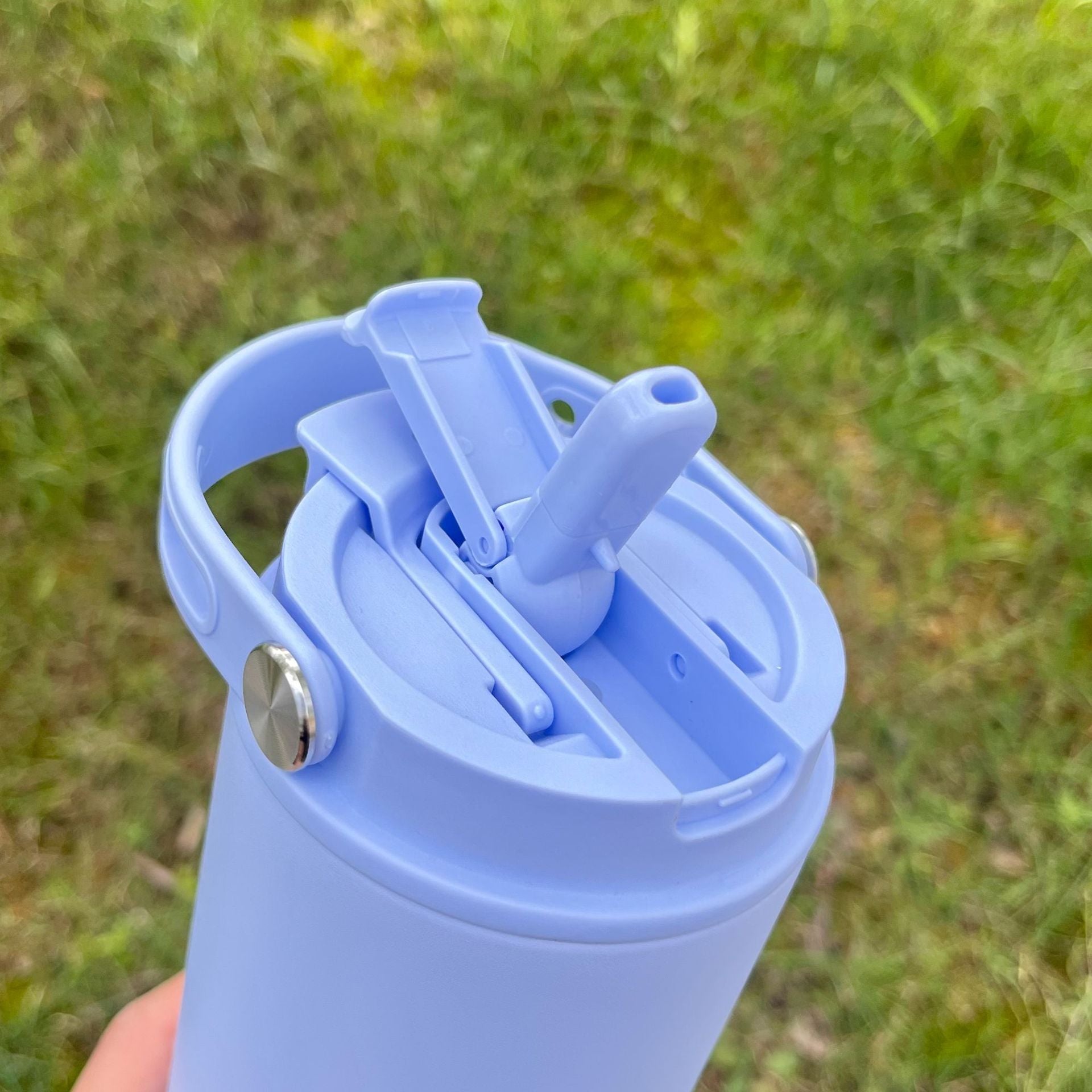 Light blue insulated bottle lid with metal drinking spout and carry handle