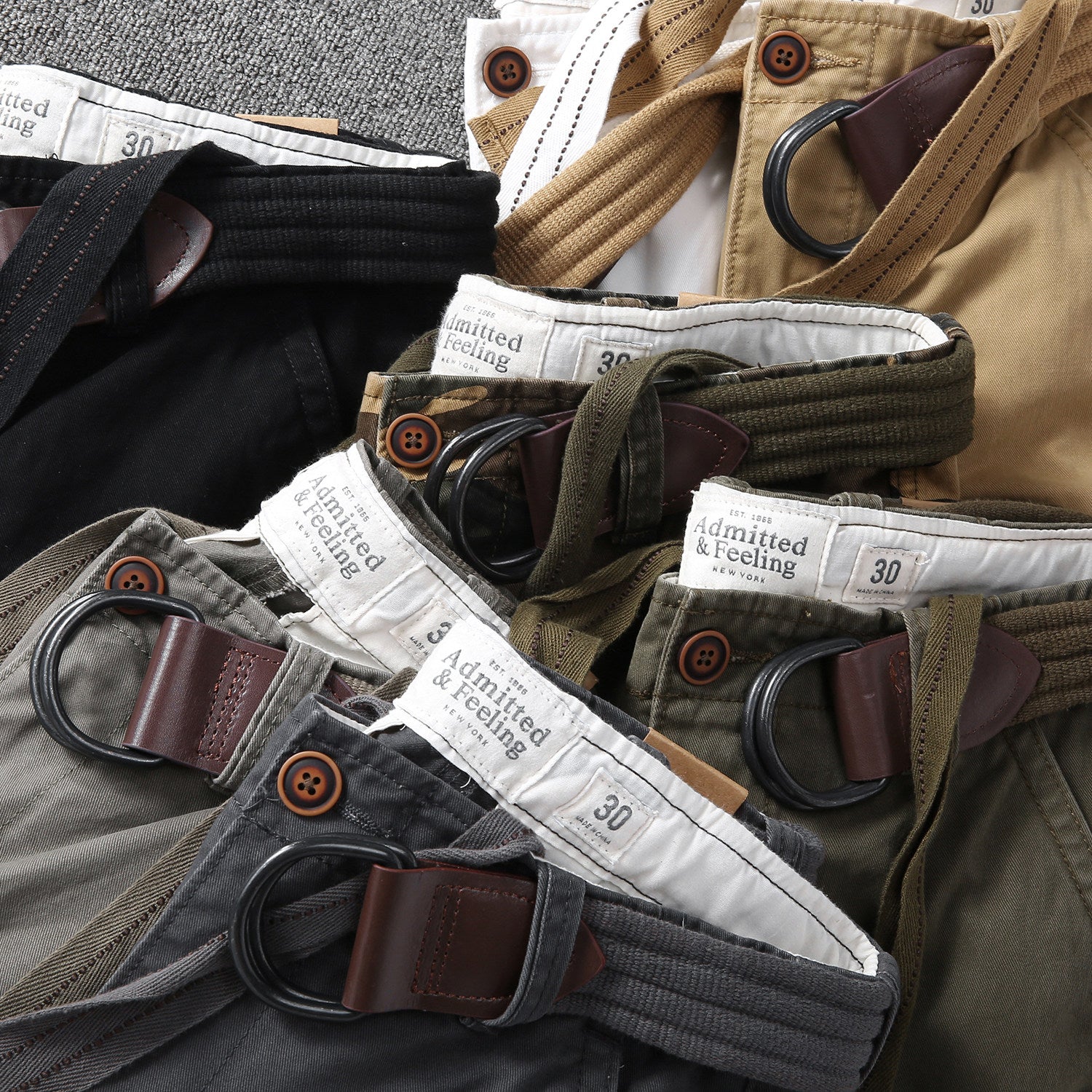 Waistband and belt loops of multi-pocket cargo shorts with button closure and metal rings