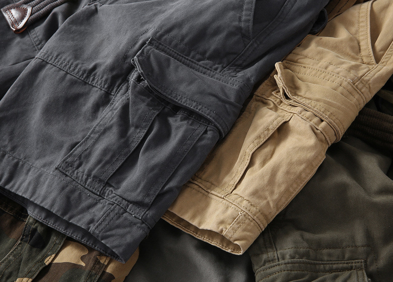 Multi-pocket outdoor shorts with flap pockets and stitched seams, in dark gray and tan
