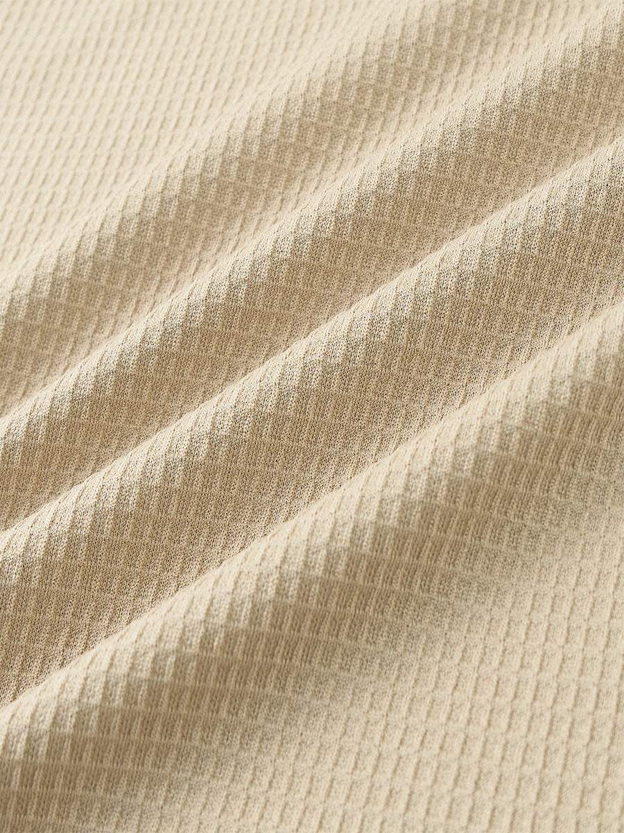 Beige waffle knit fabric texture with raised diamond pattern