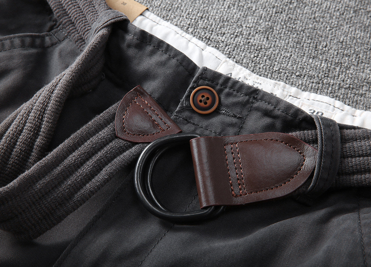 Close-up of elastic waistband and leather trim belt loop on dark cargo shorts