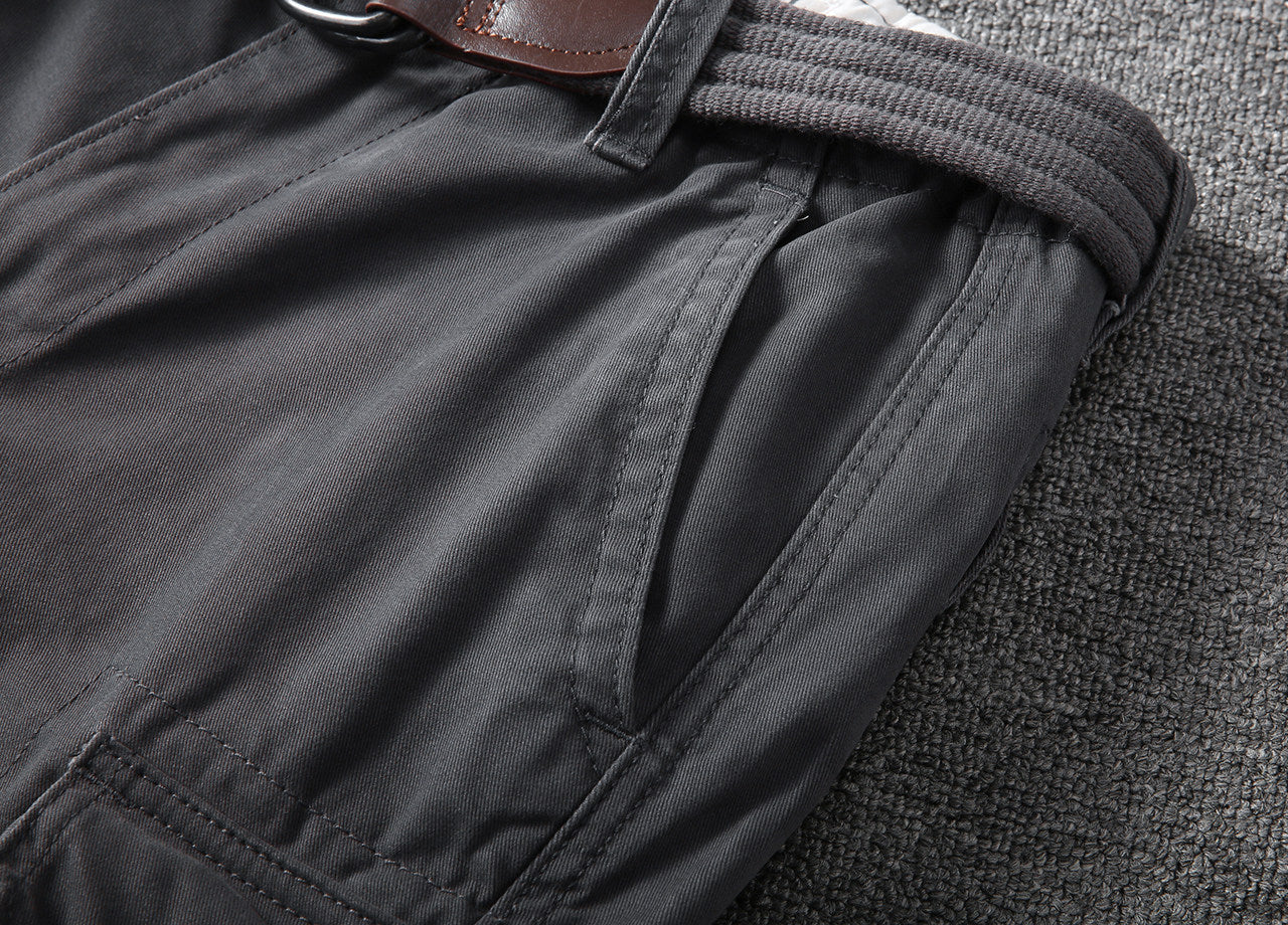 Close-up of front pocket area on dark gray cargo shorts with stitched button tab