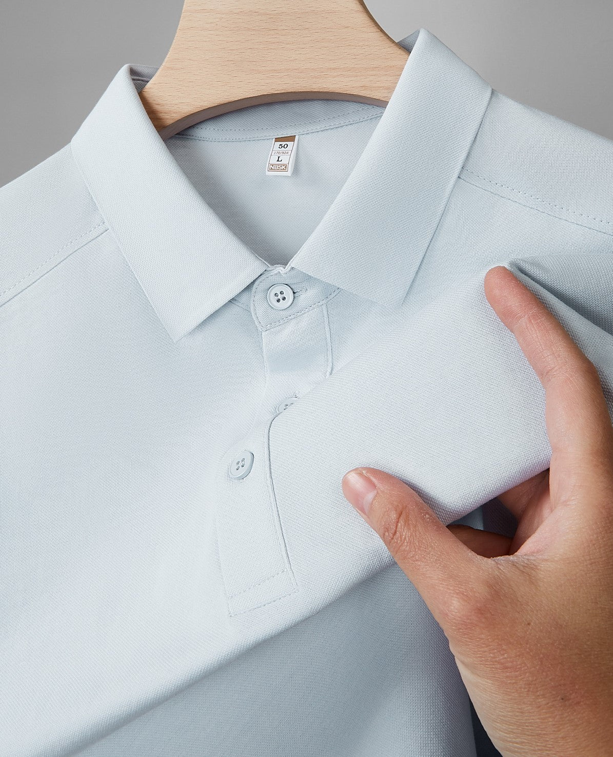Men's polo shirt in light blue with pointed collar and button placket close-up