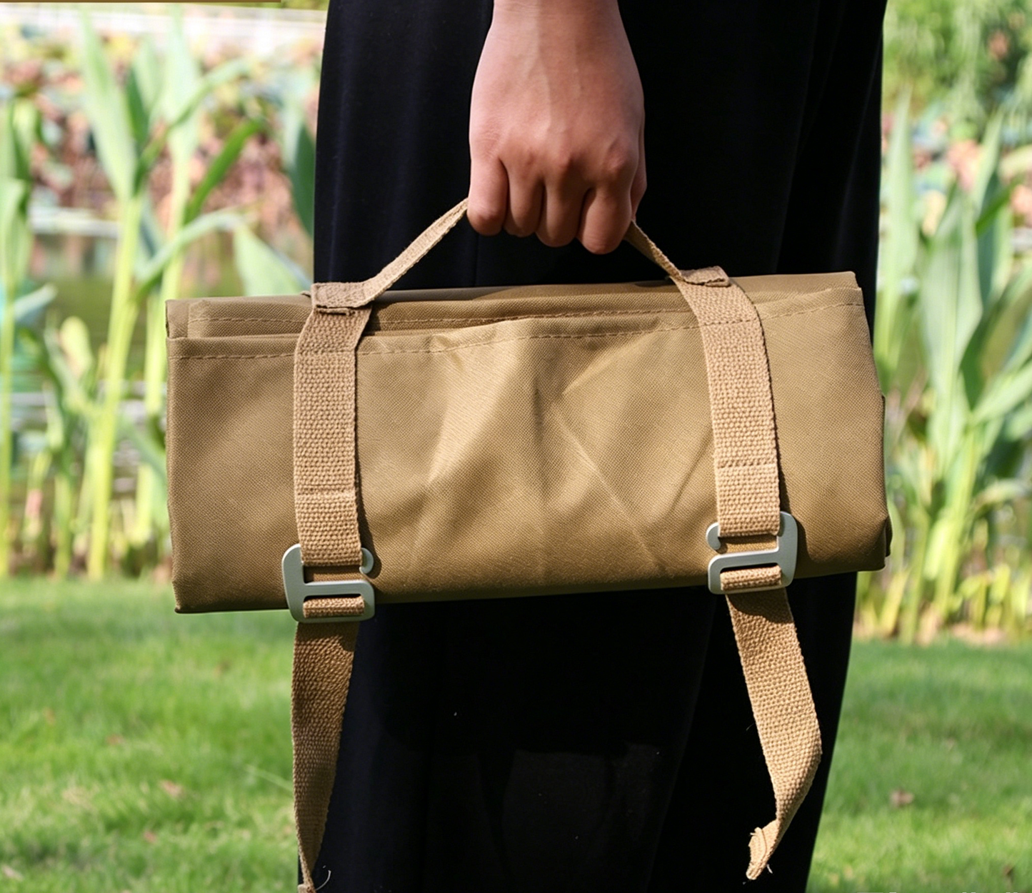 Khaki waterproof picnic and camping mat with webbing carry straps and buckles.