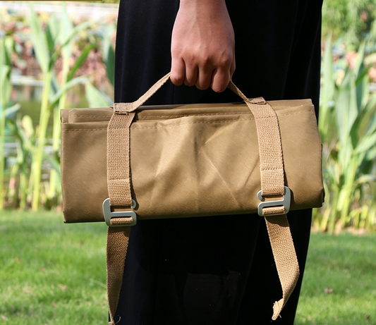Khaki waterproof picnic and camping mat with webbing carry straps and buckles.