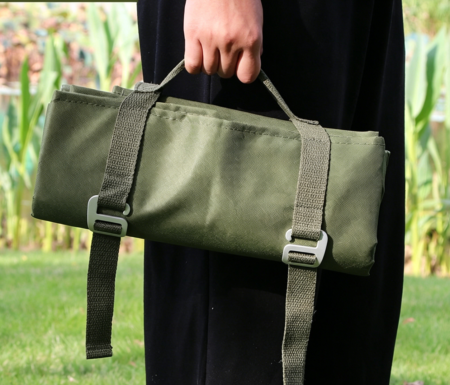 Green waterproof picnic and camping mat carry bag with adjustable webbing straps.