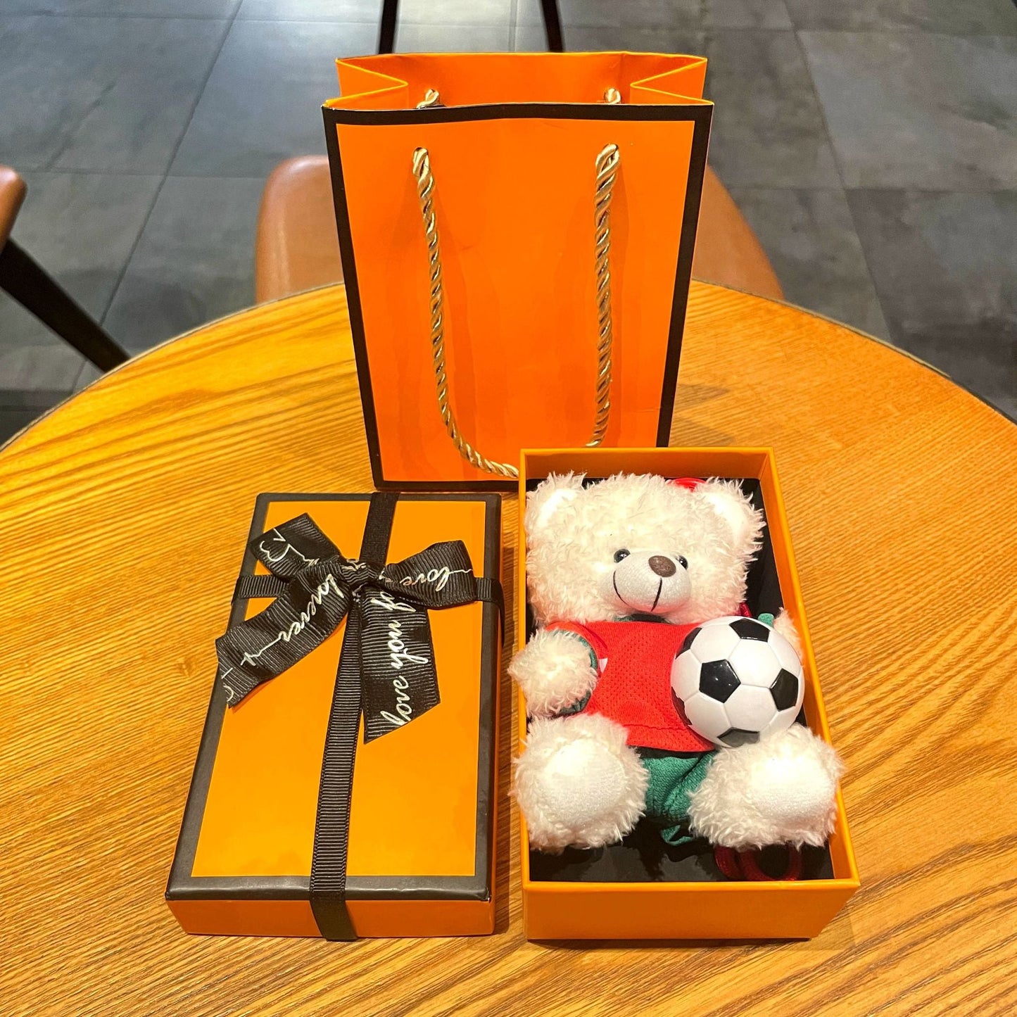 Gift box set with white plush bear keychain in red soccer jersey holding a soccer ball