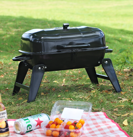 Black portable foldable charcoal grill with closed lid and stable side legs