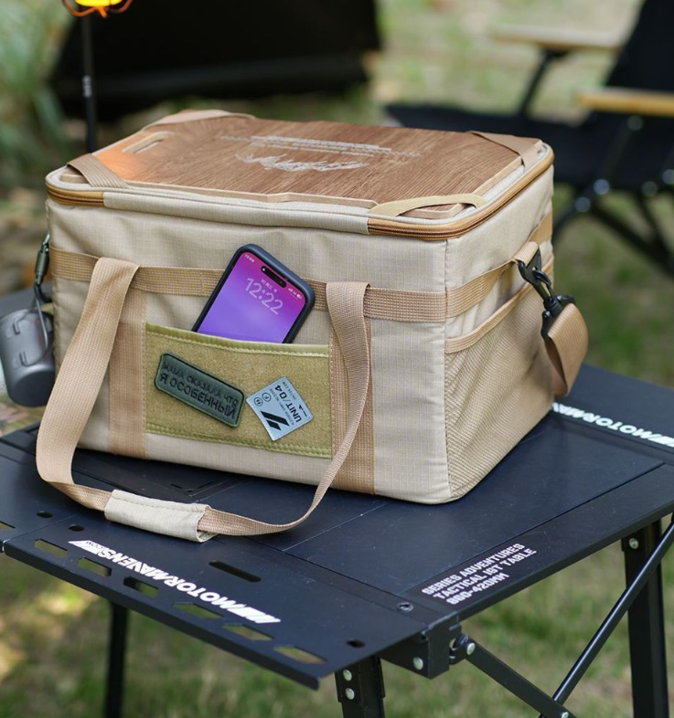 Khaki tactical storage bag with front organizer pocket holding a smartphone