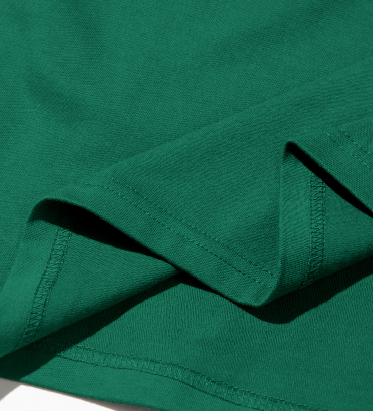 Men's green crew neck tee hem and stitched neckline edge close-up