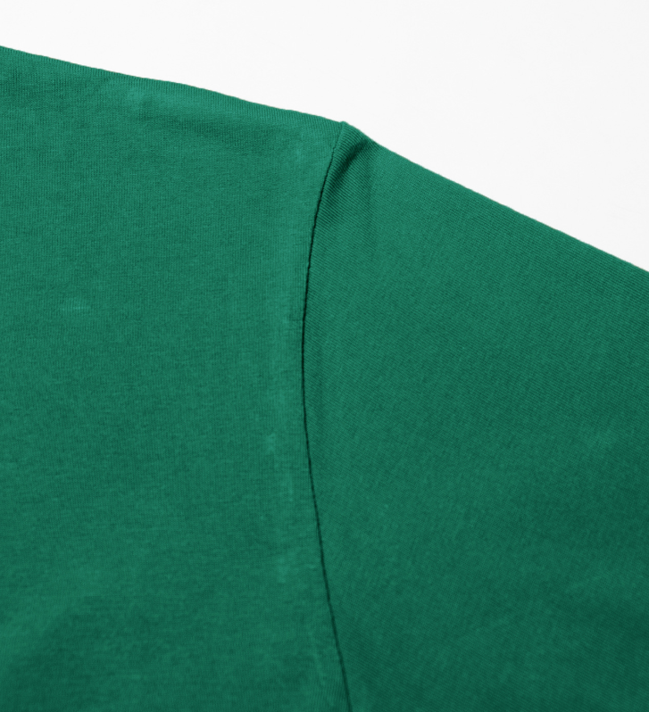 Men's green crew neck tee side seam close-up with clean stitch line