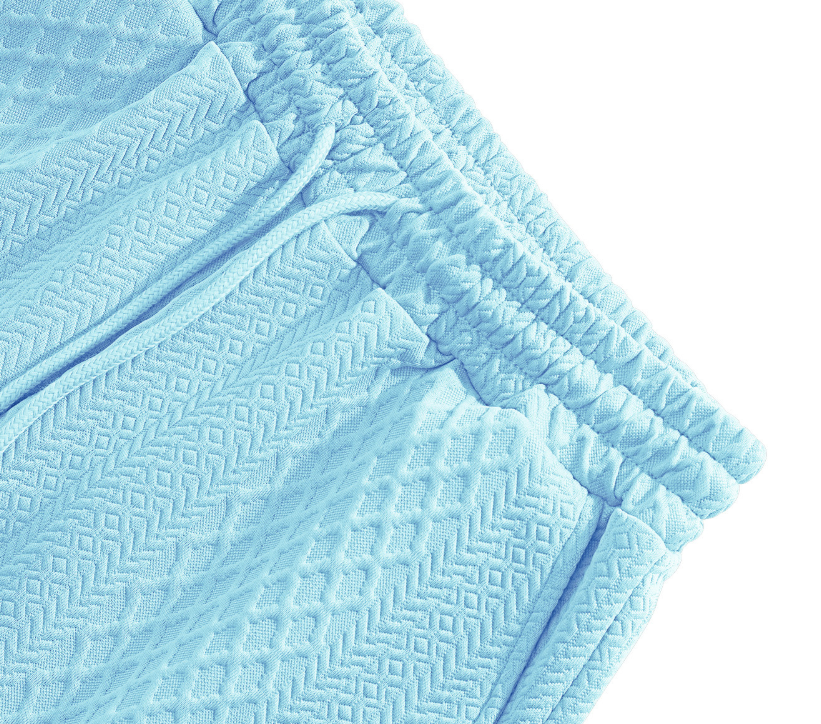 Sky blue textured polo and shorts fabric with stitched edging close-up